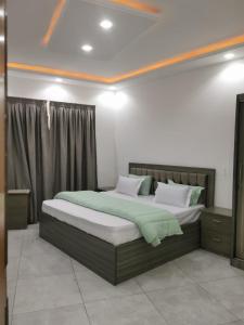 a bedroom with a large bed with green sheets at GRAND VILLA DAKAR in Dakar