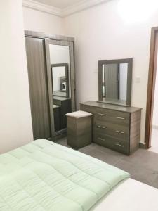 a bedroom with a bed and a dresser and mirrors at GRAND VILLA DAKAR in Dakar