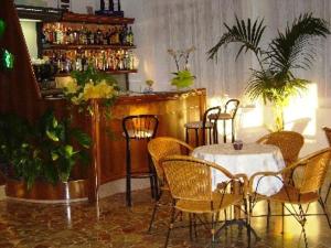 a restaurant with a table and chairs and a bar at Hotel Rosa Del Tirreno in Quercianella