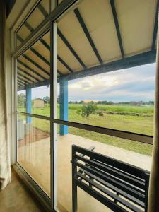 a bench in front of a window with a view of a field at RHO Sigiriya Lake Edge Retreat & Spa in Sigiriya