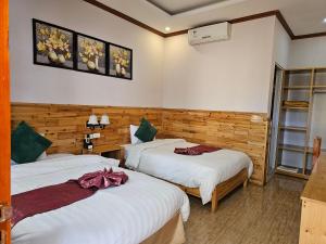 um quarto de hotel com duas camas e um quarto com duas prateleiras em Dang Khoa Garden Inn em Sapa