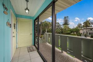a balcony with a door and a view of a street at West Bay Cove 218 condo in Holmes Beach