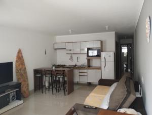 a living room with a couch and a kitchen at Casa privativa no norte da ilha in Florianópolis