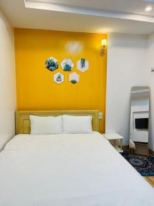 My Dream Hotel في سابا: غرفة نوم بسرير ابيض وجدار اصفر