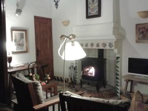 a living room with a fireplace and a lamp at Casa Sastre Segui in Patró