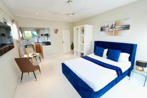 a bedroom with a blue and white bed and a table at Lukas Garden Accra in Accra