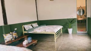 ein Schlafzimmer mit einem Bett und einer grünen Wand in der Unterkunft Stella Đồng Lâm Homestay in Làng Ben