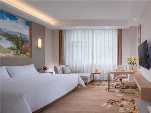 una habitación de hotel con una cama grande y una mesa en Vienna International Hotel (Lianjiang Avenue Xinyuan International Plaza), en Lianjiang