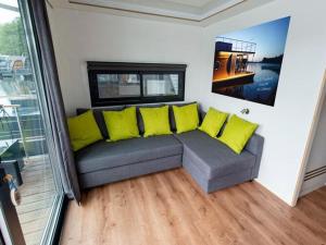 a living room with a couch with yellow pillows at Houseboat on the Dahme, Wildau in Königs Wusterhausen