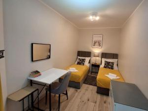 a small room with two beds and a table and chairs at Comfortable apartment for 5 people, Dar ówko in Darłówko