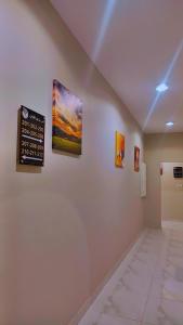 a hallway with paintings on the walls of a room at جوهرة العزيزية للشقق المفروشة in Medina