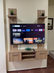a large flat screen tv sitting on a wooden stand at Departamento Horizonte in Manta
