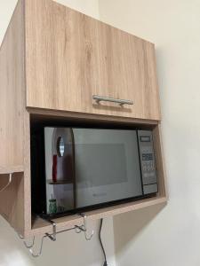 a microwave in a wooden cabinet on a wall at Departamento Horizonte in Manta