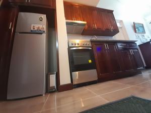 a kitchen with a stainless steel refrigerator and wooden cabinets at Beach 1 Bedroom 32 in Ocho Rios