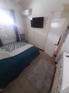 Dormitorio pequeño con cama y TV en Beach 1 Bedroom 32 en Ocho Rios