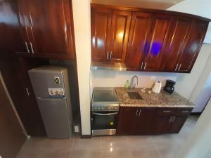 a kitchen with wooden cabinets and a refrigerator at Beach 1 Bedroom 32 in Ocho Rios