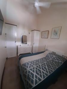 1 dormitorio con 1 cama, vestidor y ventilador de techo en Beach 1 Bedroom 32 en Ocho Rios