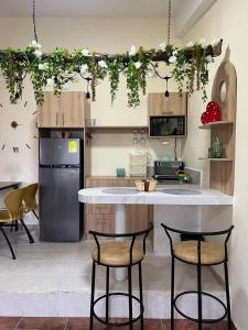 a kitchen with two bar stools and a counter in a kitchen at Departamento Horizonte in Manta