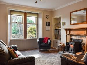 a living room with a couch and a fireplace at Caldhame Smiddy in Marykirk
