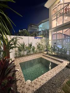 a swimming pool in front of a house at night at RICH-VANIA SUITES in General Luna