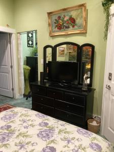 a bedroom with a dresser with a television and a mirror at Private small suite with private bathroom and parking on property in Vernon