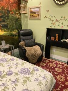 a bedroom with a chair and a bed and a painting at Private small suite with private bathroom and parking on property in Vernon