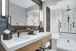 a bathroom with two sinks and a shower at The Farnam, Autograph Collection in Omaha