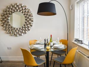 a dining room with a table and chairs and a mirror at The Gables in Helmsley