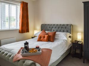a bedroom with a bed with a tray of food on it at The Gables in Helmsley