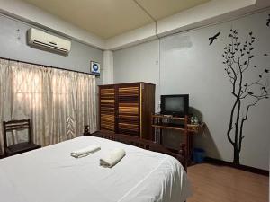 1 dormitorio con 1 cama con 2 toallas en Domon Riverside Hotel, en Vang Vieng