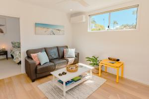 a living room with a couch and a table at Private and peaceful house near the Beach in Coolum Beach