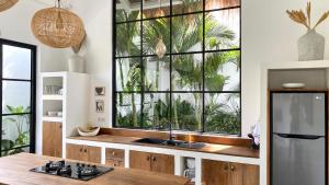 チャングーにあるThe Young Villas - Cangguのシンクと大きな窓のあるキッチン