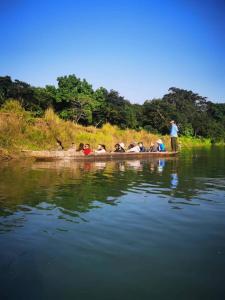 um grupo de pessoas em um barco em um rio em Sauraha BnB em Sauraha