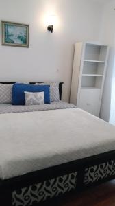 a bedroom with a large white bed with blue pillows at Nuwara eliya Luxury Apartment in Nuwara Eliya