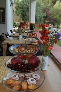 einen Tisch mit drei Tabletts Essen und Blumen in der Unterkunft Almà in Torre delle Stelle