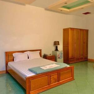 ein Schlafzimmer mit einem Bett und einem Schrank in einem Zimmer in der Unterkunft MẠNH LÊ GIA HOTEL in Plei Brel (2)