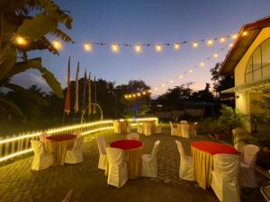 a group of tables and chairs in a backyard at night at Urban Villa in Guwahati