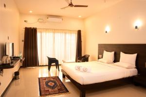 a hotel room with a large bed and a kitchen at Mastiff Select Shreeyog Resort in Dandeli