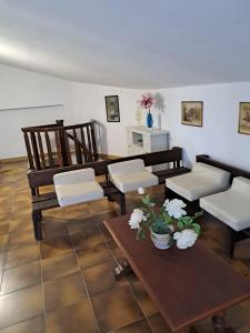 ein Wohnzimmer mit Stühlen, einem Tisch und einem Tisch in der Unterkunft Villa Andres in Sassari