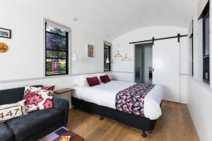 a bedroom with a bed and a couch at Nambucca Valley Train Carriages in Nambucca