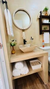 W łazience znajduje się umywalka, lustro i ręczniki. w obiekcie Departamento AJAL TULUM w mieście Tulum