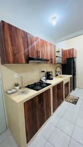 cocina con armarios de madera y horno con fogones en Departamento AJAL TULUM, en Tulum