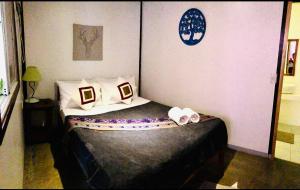 a small bedroom with a bed with white sheets and pillows at Keira Backpackers in El Nido +70 photos