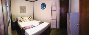 Habitación pequeña con cama y escalera en Keira Backpackers, en El Nido