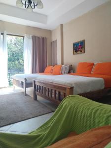 a bedroom with two beds with orange pillows and a window at Campestre House in Alto Boquete