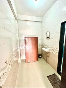 łazienka z czerwonymi drzwiami i umywalką w obiekcie Sea Bliss Resort w mieście Kolthare