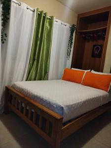 sypialnia z łóżkiem z białymi zasłonami i pomarańczowymi poduszkami w obiekcie Campestre House w mieście Alto Boquete