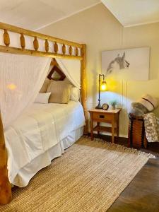 a bedroom with a bed and a table with a lamp at B-B Ranch Cottage~Heart of Gold Country~*HOT TUB* in Pilot Hill