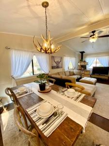 a living room with a table and a chandelier at B-B Ranch Cottage~Heart of Gold Country~*HOT TUB* in Pilot Hill