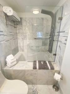 a bathroom with a shower and a tub with towels at B-B Ranch Cottage~Heart of Gold Country~*HOT TUB* in Pilot Hill